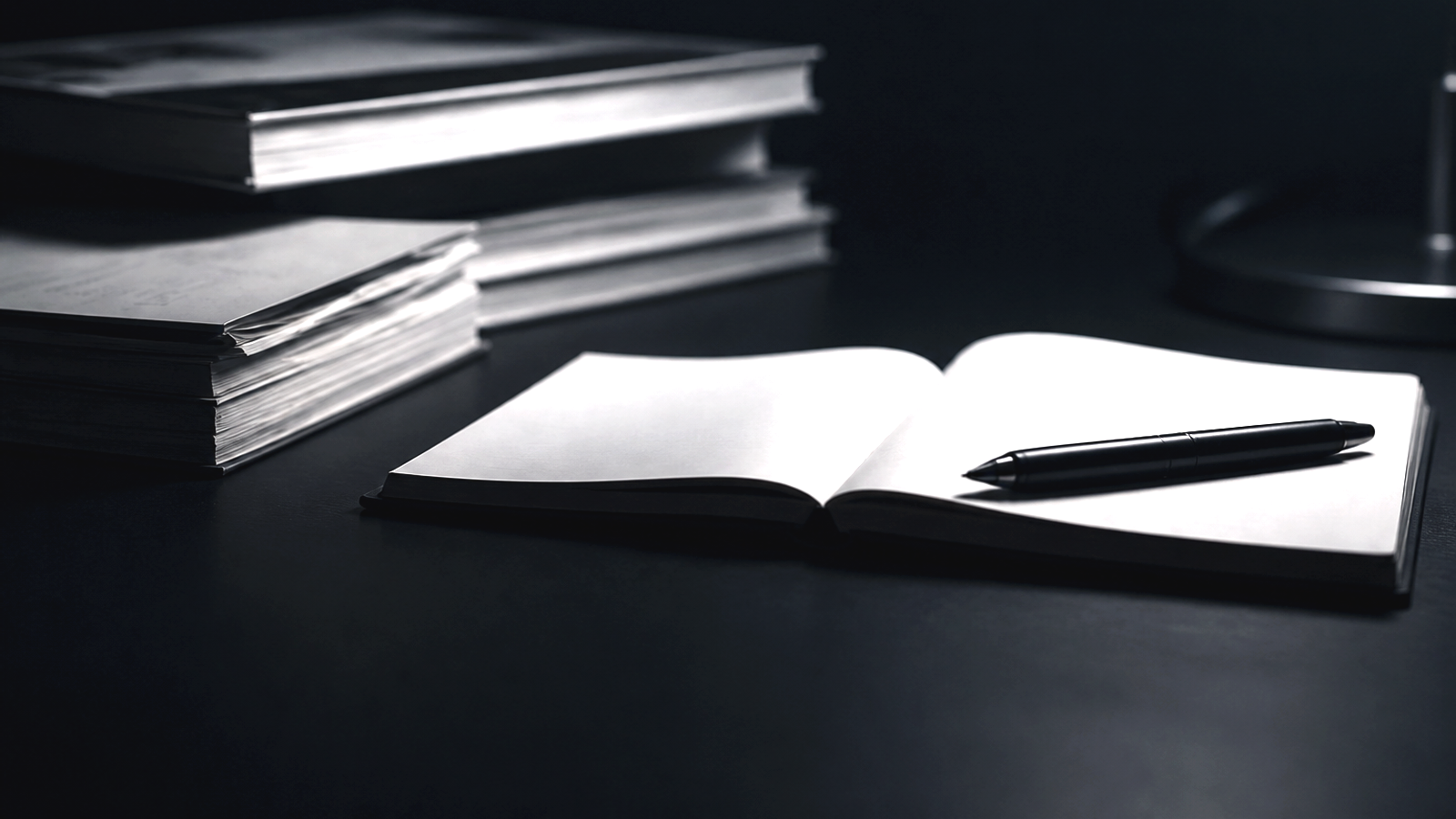 Dark article desk cover image with notebook and pen